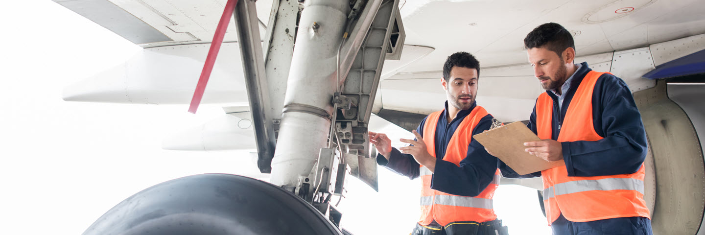 Ground crew checking airplane's landing gear at the airport